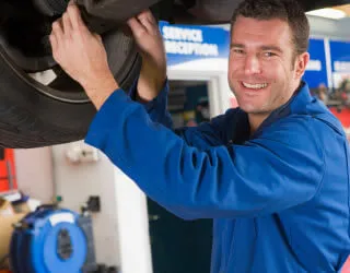 MOT tester inspecting a vehicle on a ramp